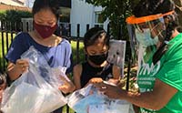 Photo of three people distributing PPE
